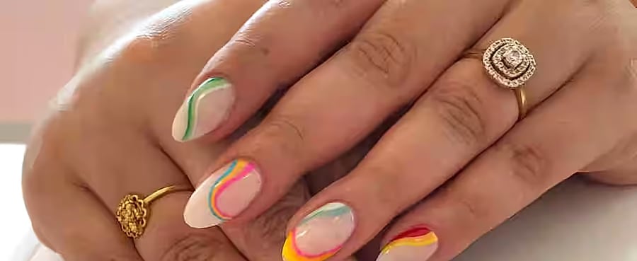 Cream nails with colourful abstract rainbow swirls