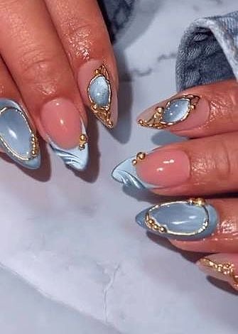 Soft-blue marble nails with gold beads and moonstone gems