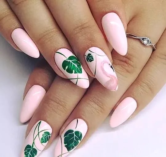 Pale pink nails hand-painted with monstera leaves and a flamingo